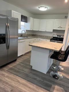 a kitchen with stainless steel appliances granite countertop a sink refrigerator and cabinets