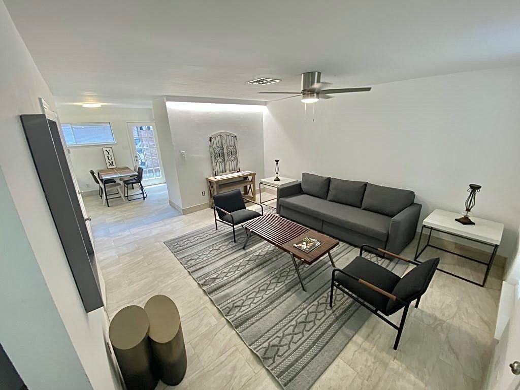 a living room with furniture and wooden floor