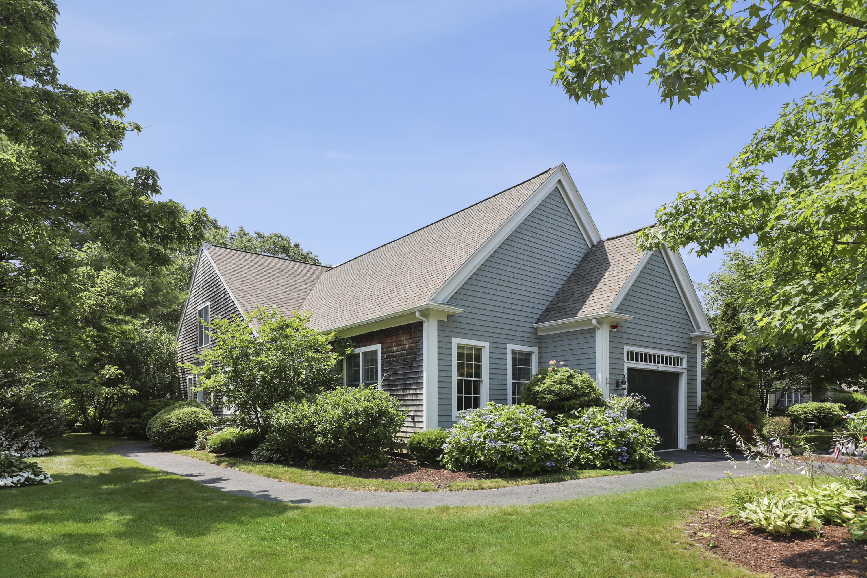 a front view of a house with a yard and potted plants