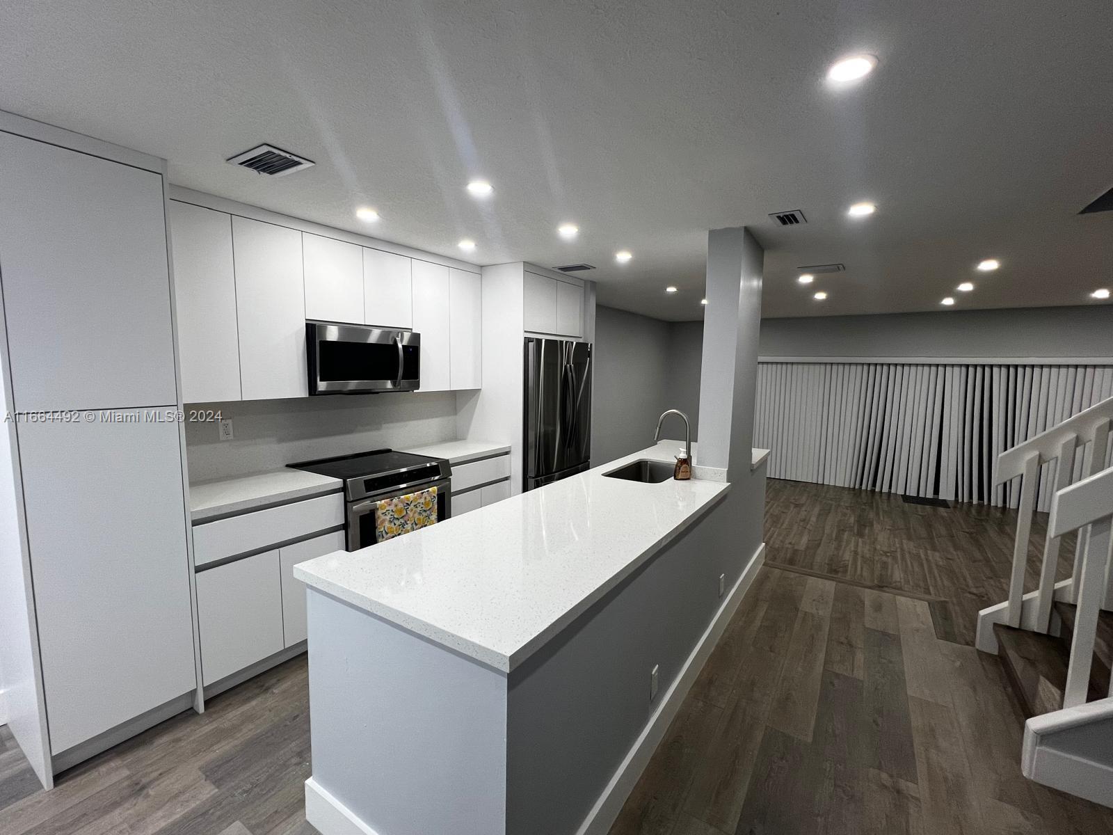 a kitchen with a sink stainless steel appliances and cabinets