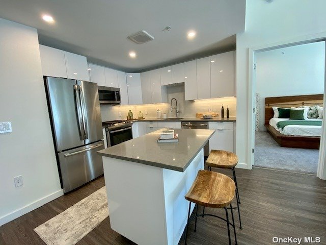 a kitchen with stainless steel appliances granite countertop a refrigerator a sink and a stove