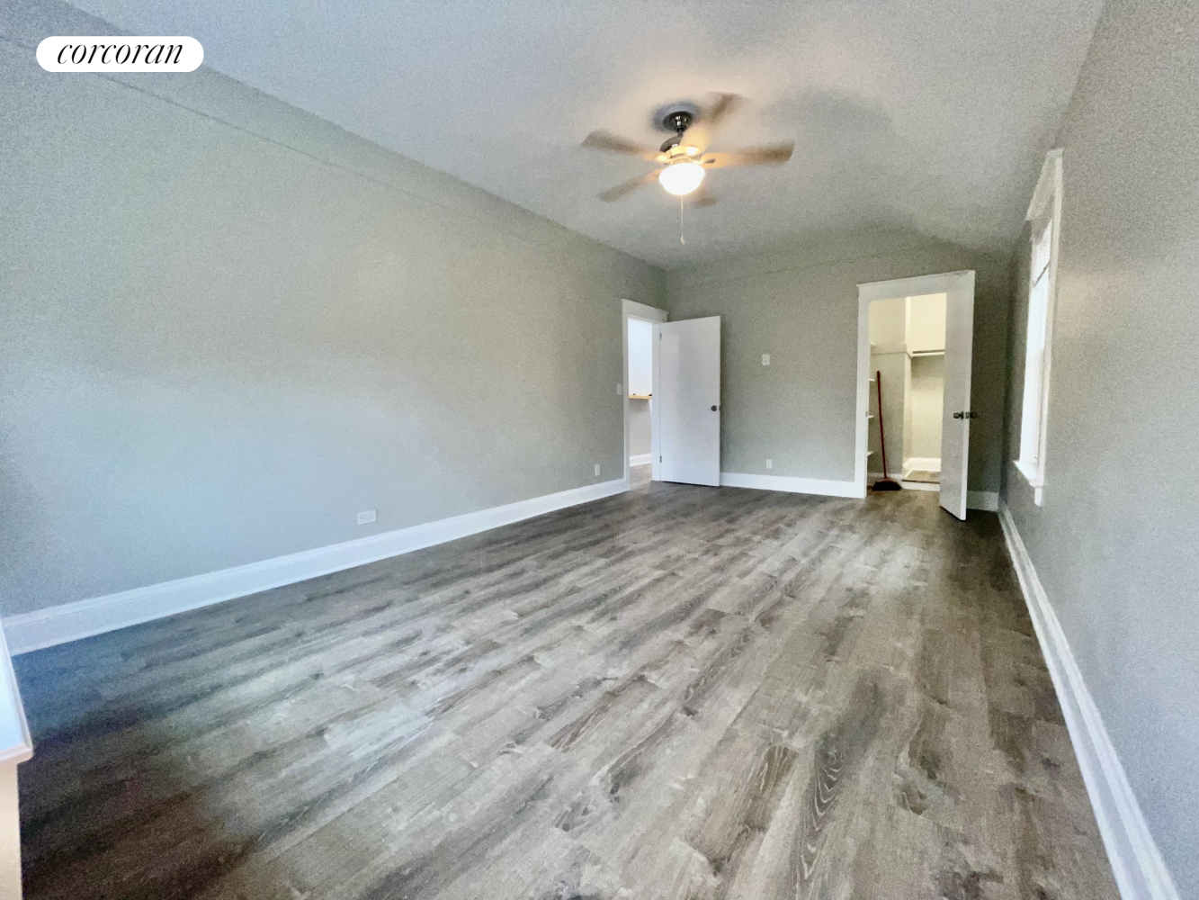 a view of an empty room with a chandelier fan