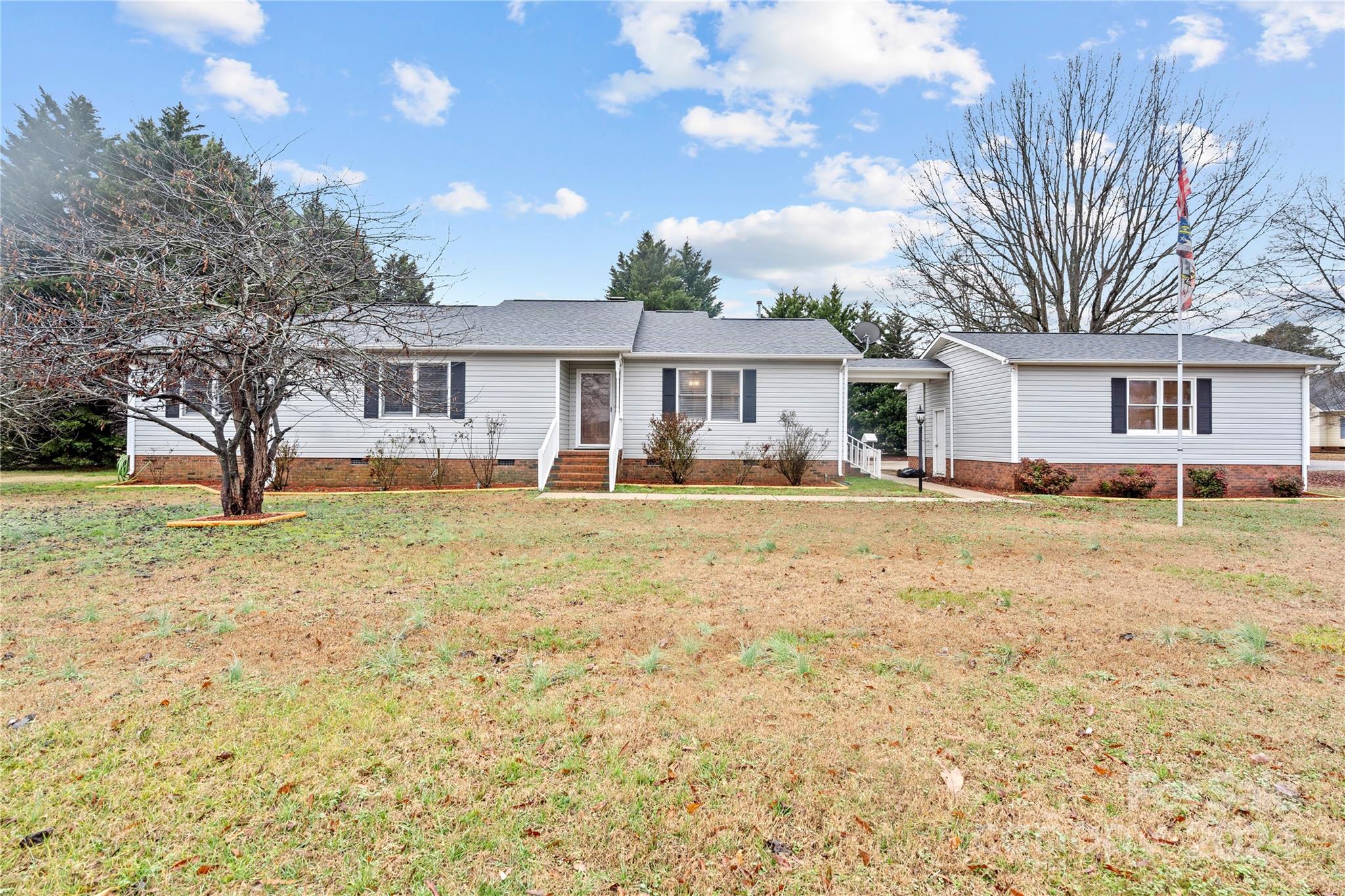 a front view of house with yard and trees around