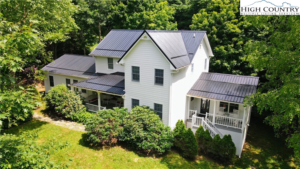 a aerial view of house with yard and trees in the background