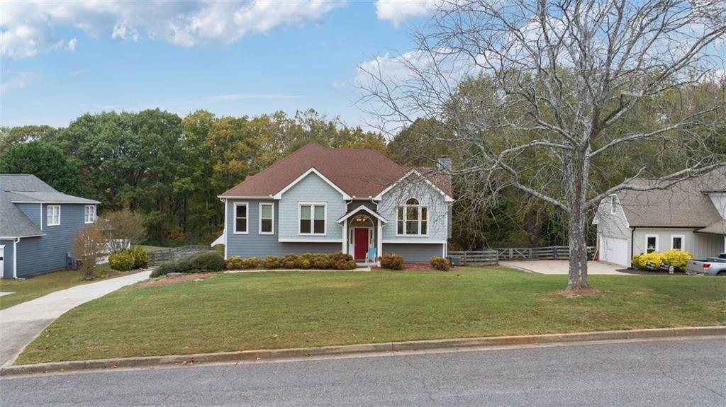 a front view of a house with a yard and trees