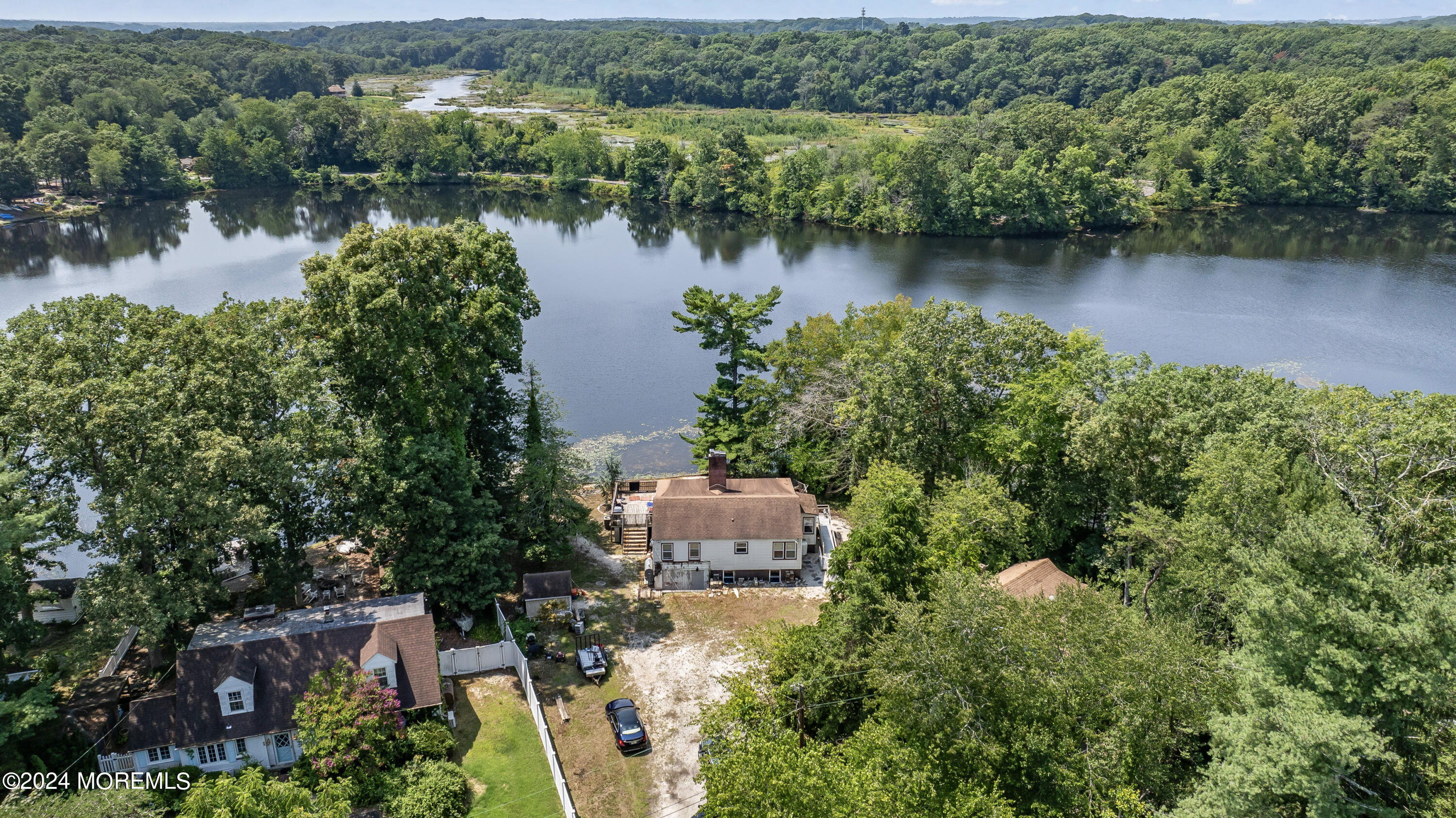 an aerial view of a house with a yard and a lake view