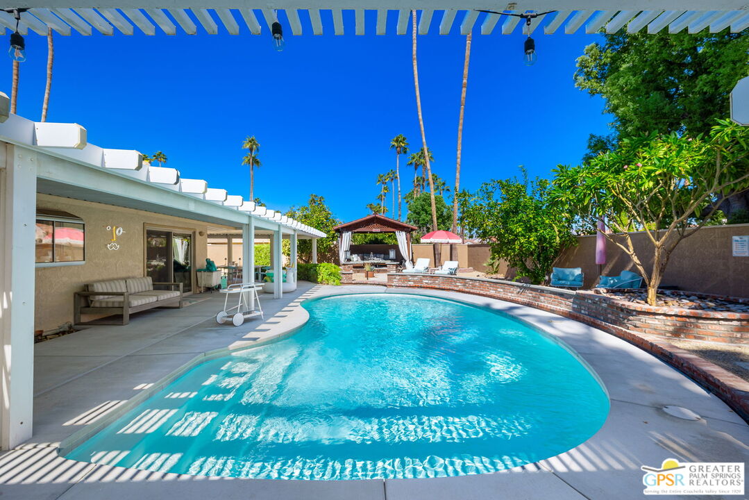 a swimming pool with outdoor seating and yard