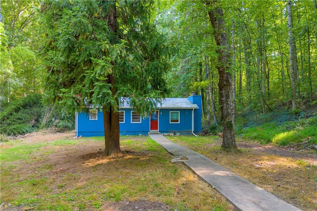 a view of a house with backyard and tree