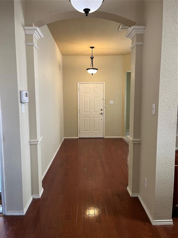 a view of a hallway with a chandelier fan and wooden floor