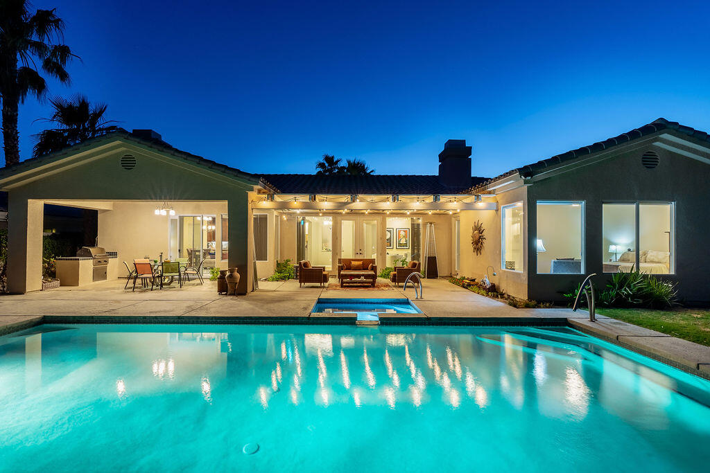 a view of an house with swimming pool and chairs