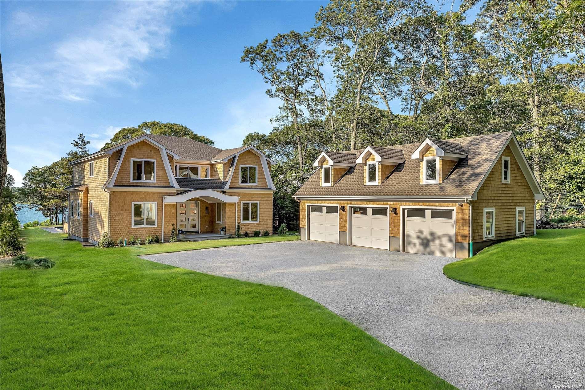 a front view of a house with a garden and trees