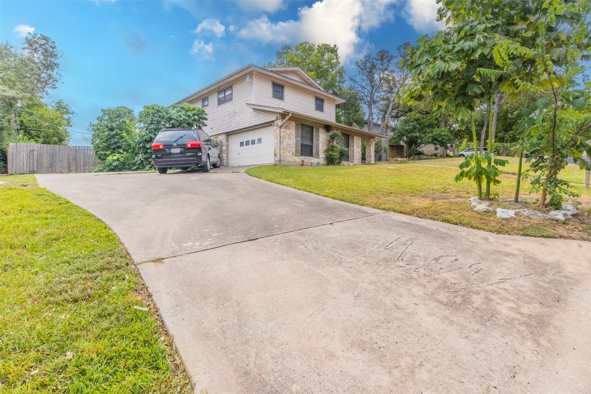 a front view of a house with a yard and potted plants