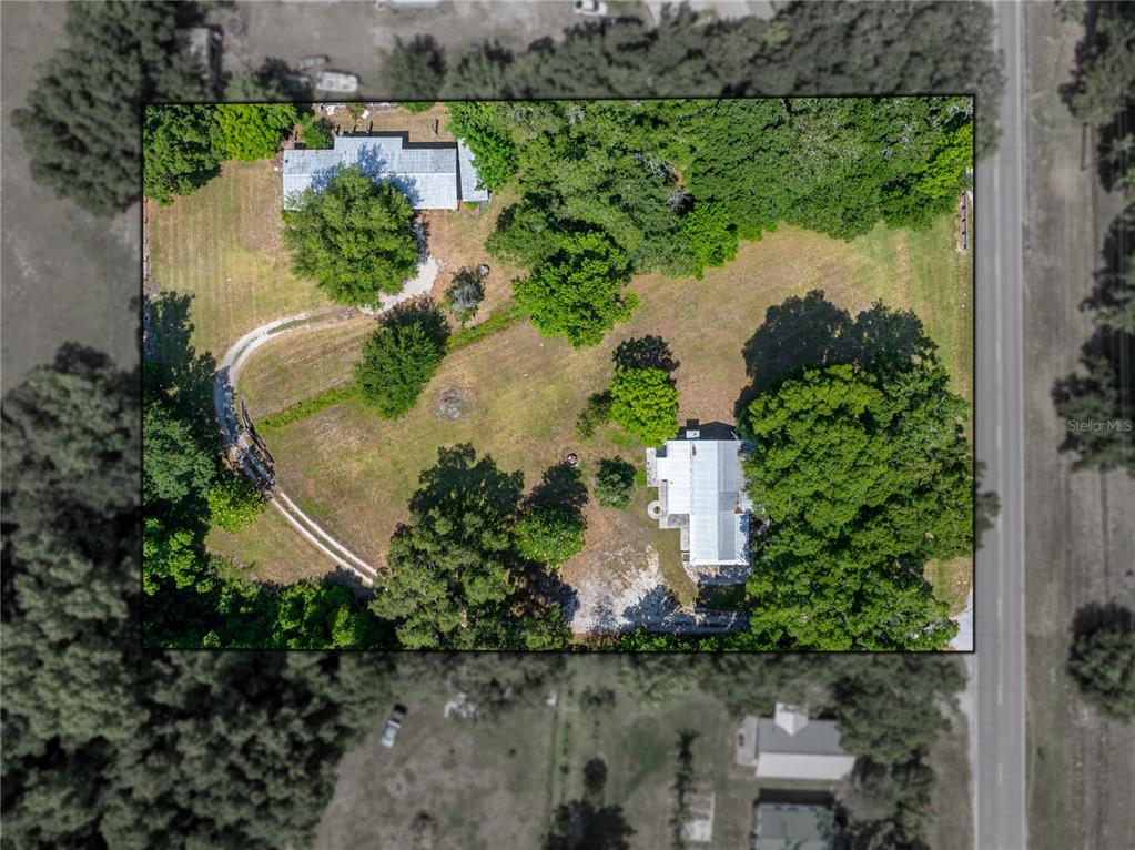 an aerial view of a house with a yard and lake view