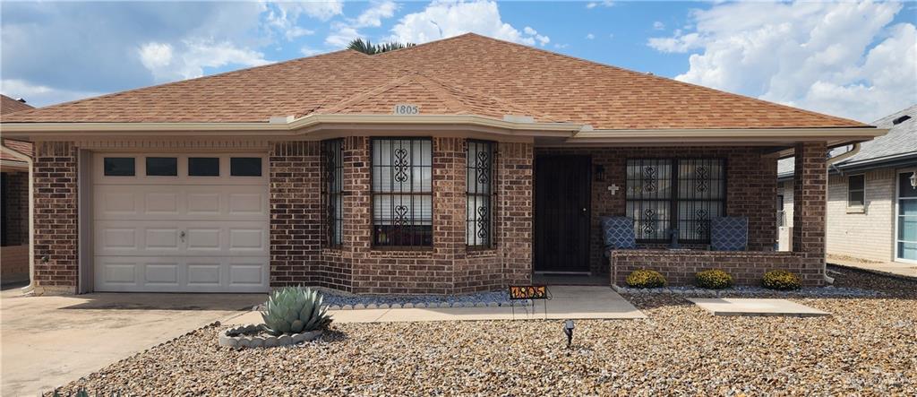 Single story home with a porch and a garage