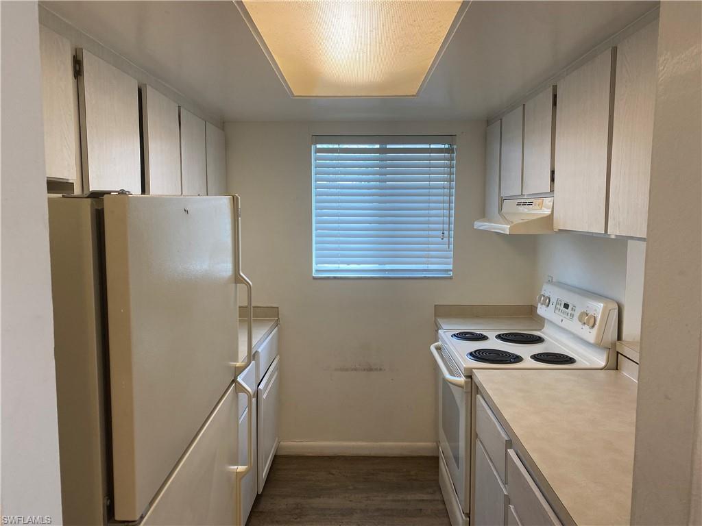 a kitchen with a refrigerator and a stove top oven