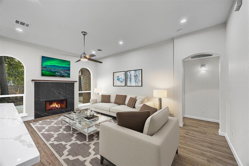 a living room with furniture a fireplace and a flat screen tv