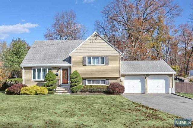 a front view of a house with a garden and yard