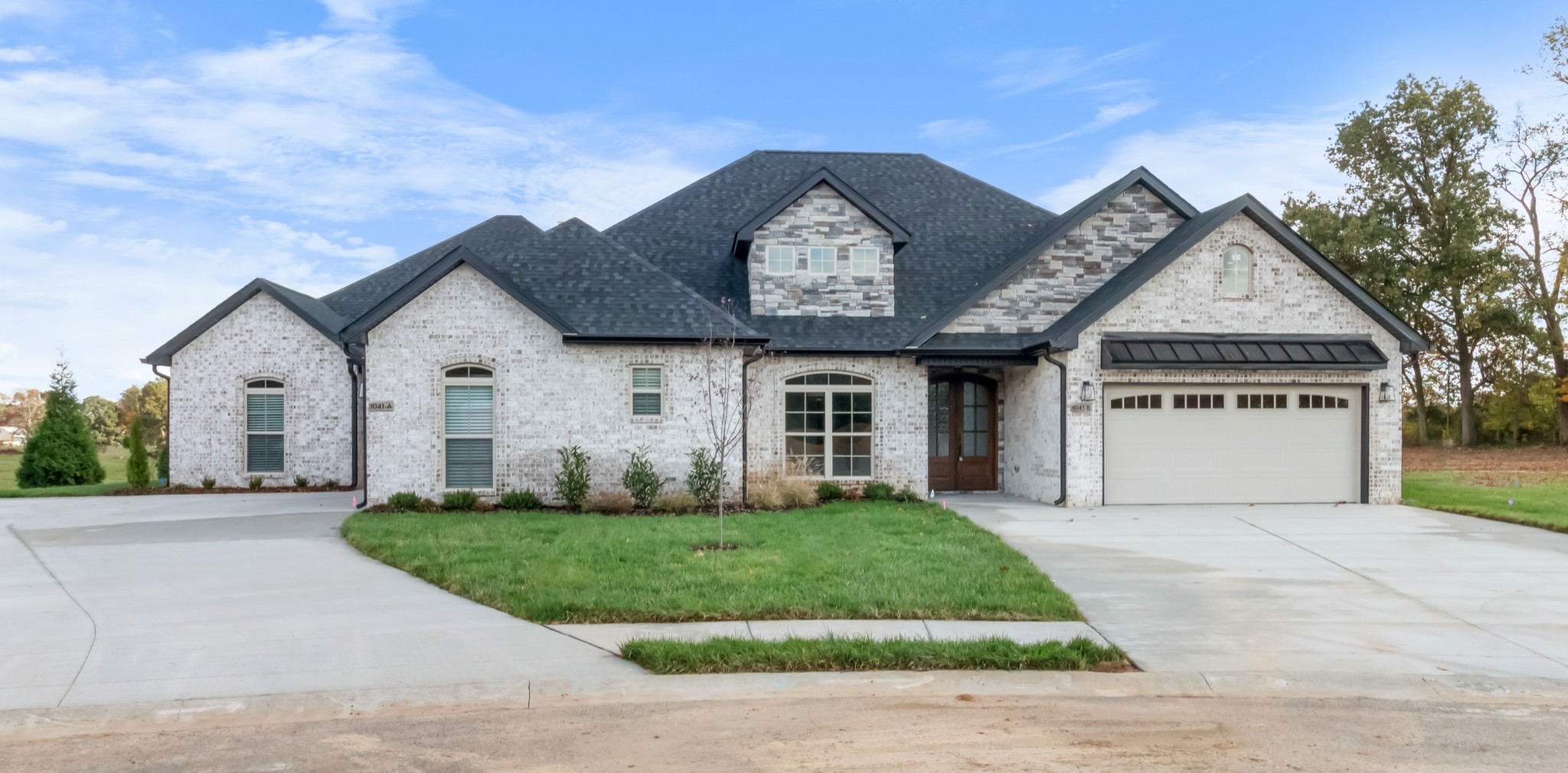 a front view of a house with a yard and garage