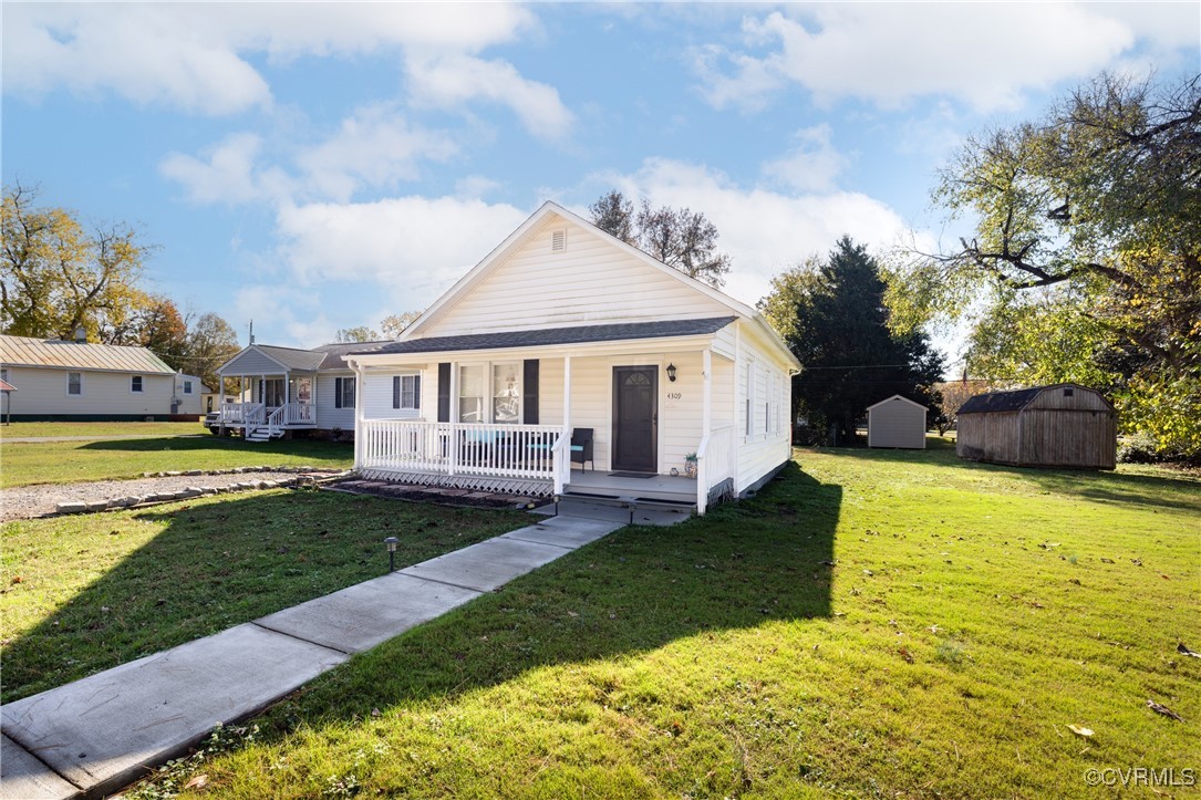 Bungalow with covered porch, a front lawn, and a s