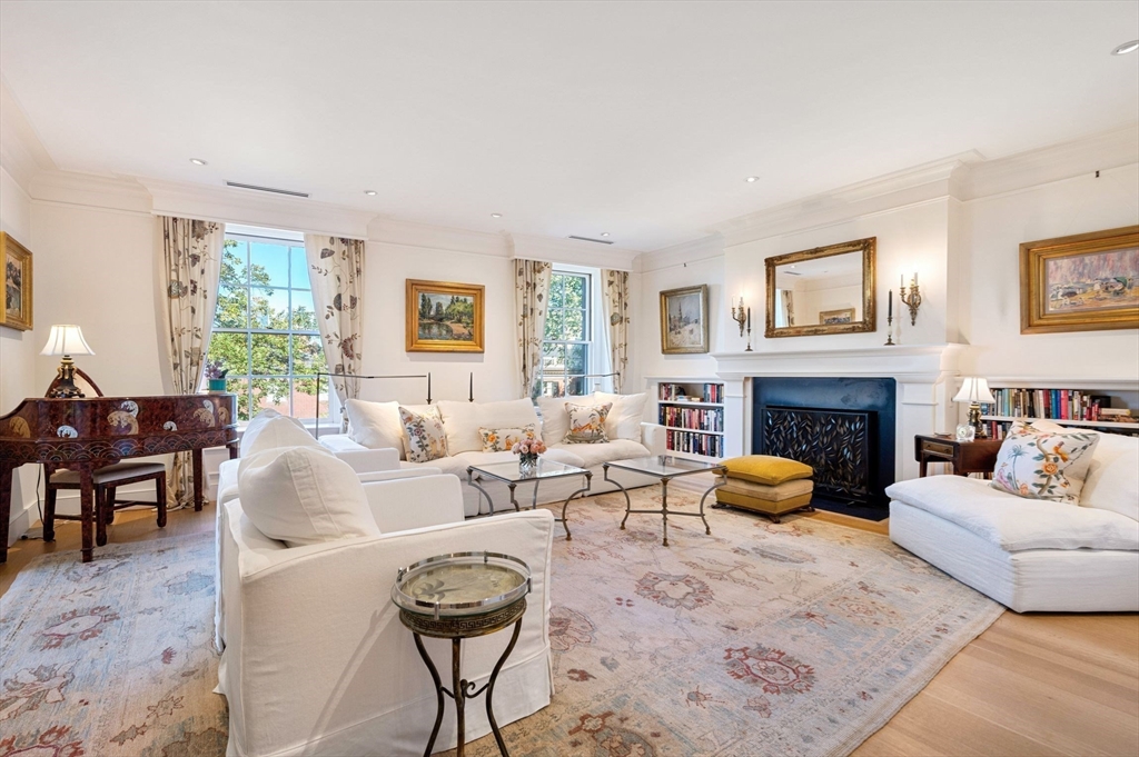 a living room with furniture a large window and a fireplace