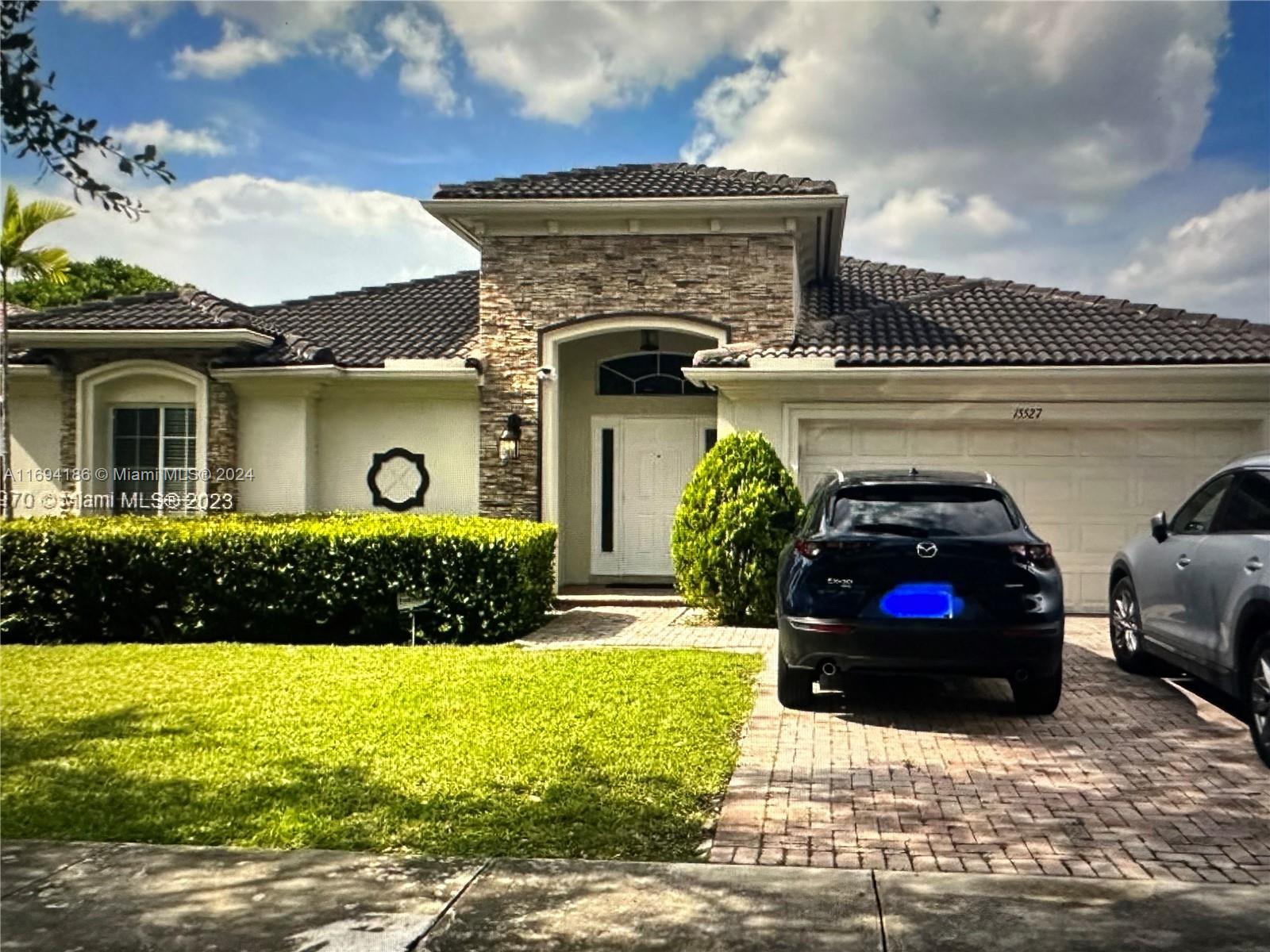 a front view of a house with a garden