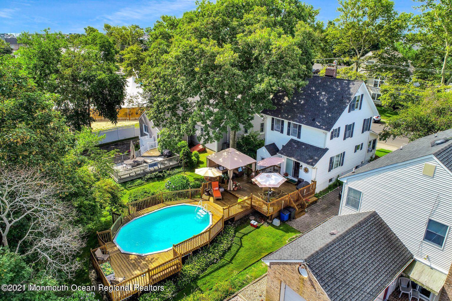 an aerial view of a house with swimming pool and trees