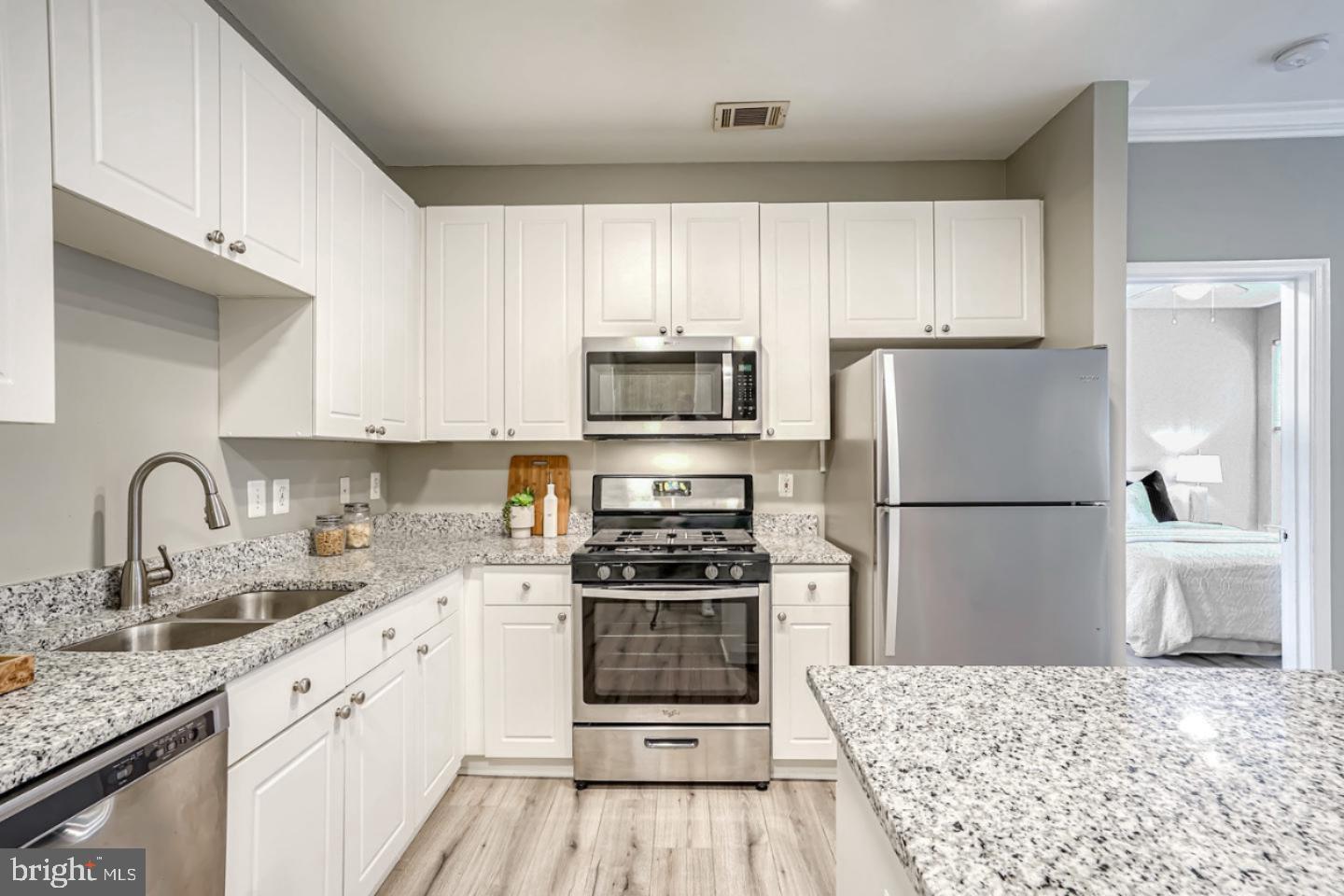 a kitchen with a refrigerator sink and wooden cabinets