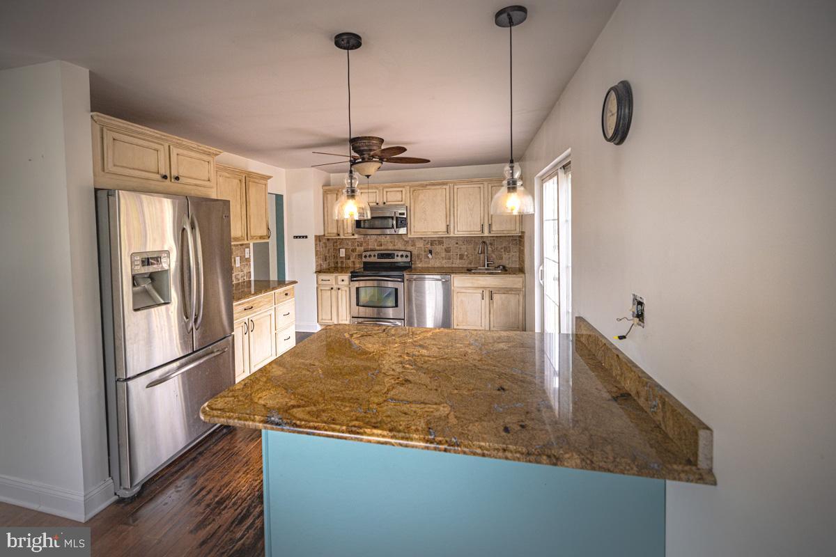 a kitchen with stainless steel appliances granite countertop a sink and refrigerator