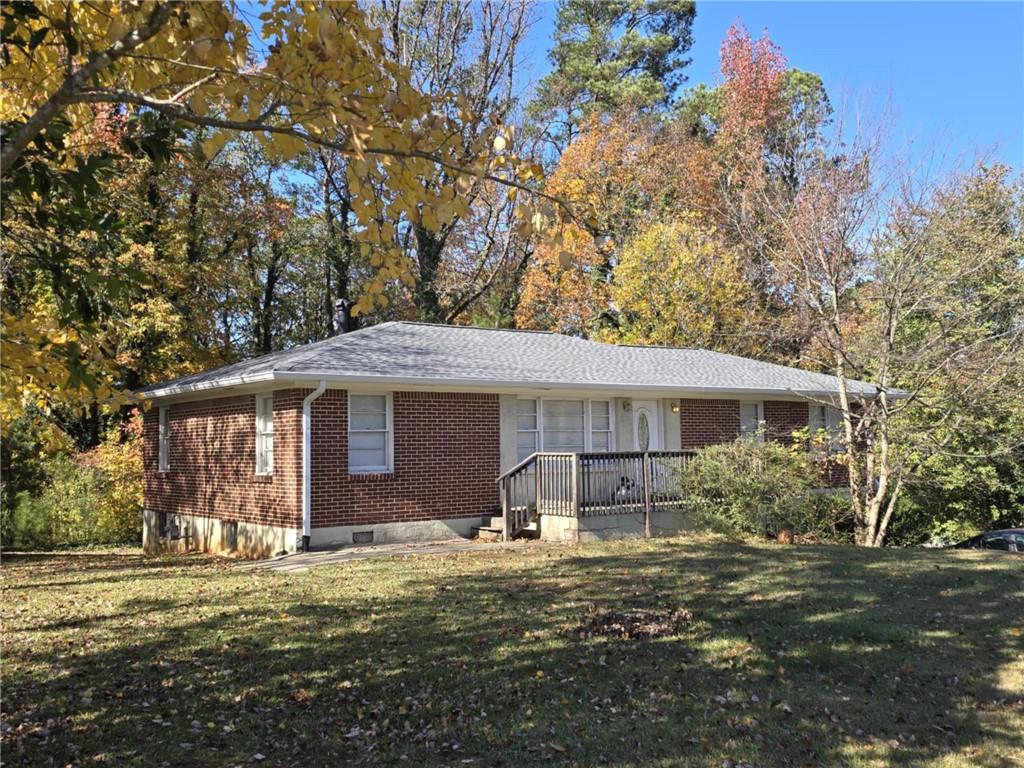 a front view of house with yard and trees around