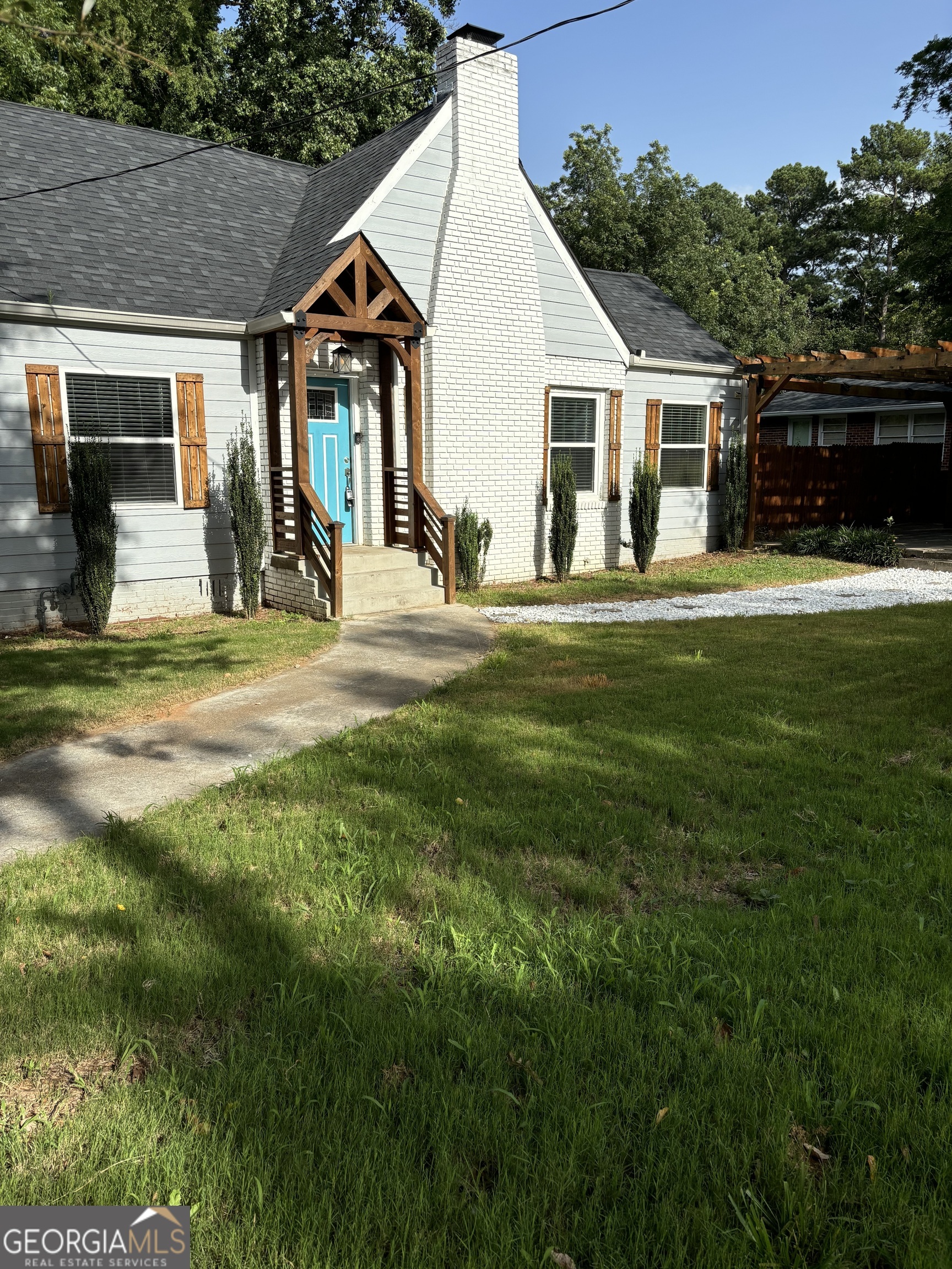 a view of a house next to a big yard and large trees