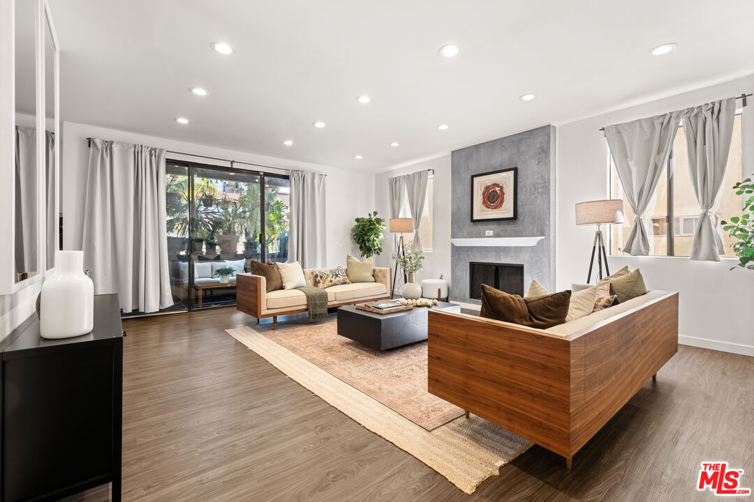 a living room with fireplace furniture and a large window