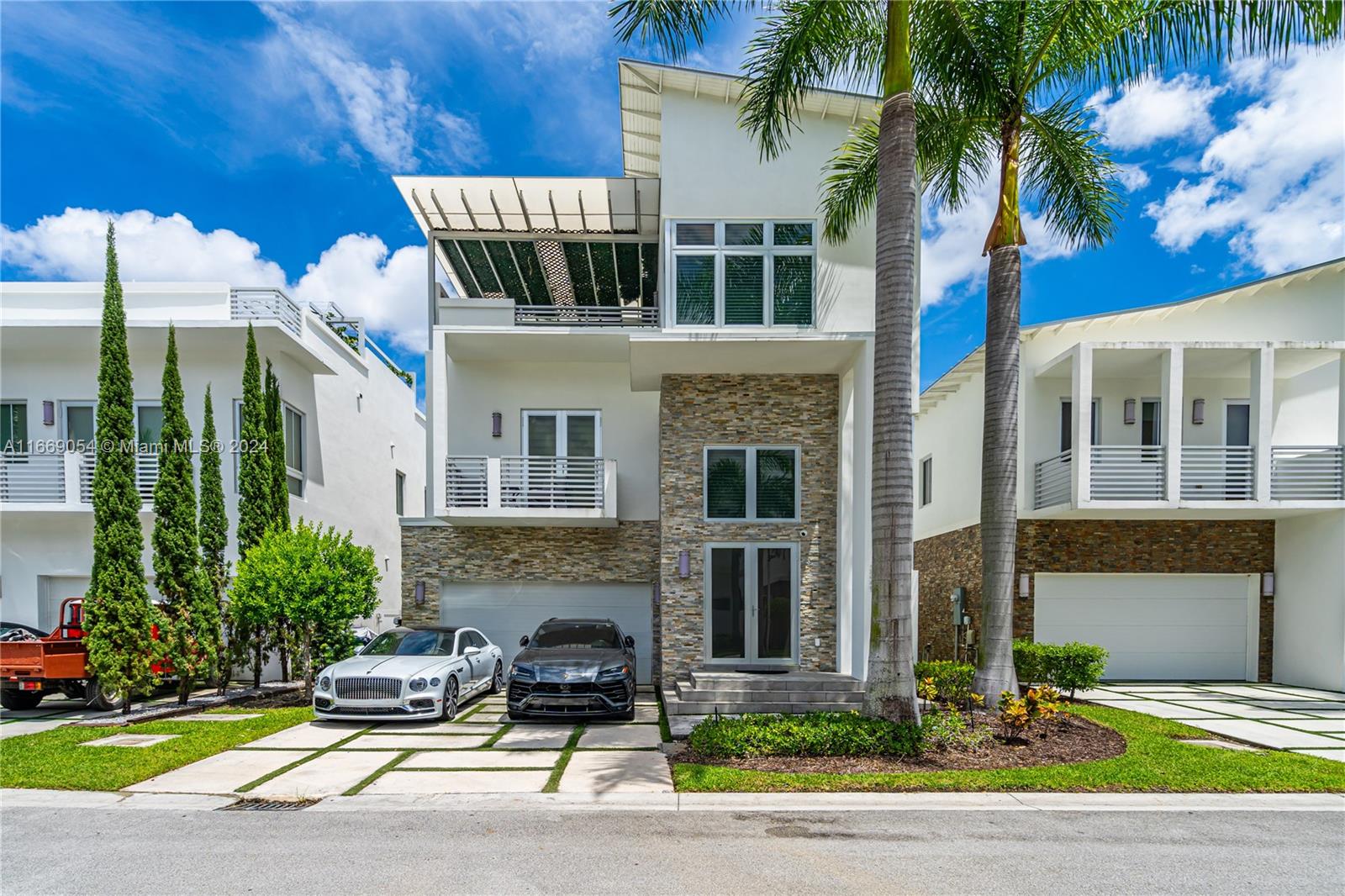 a front view of a house with yard and parking