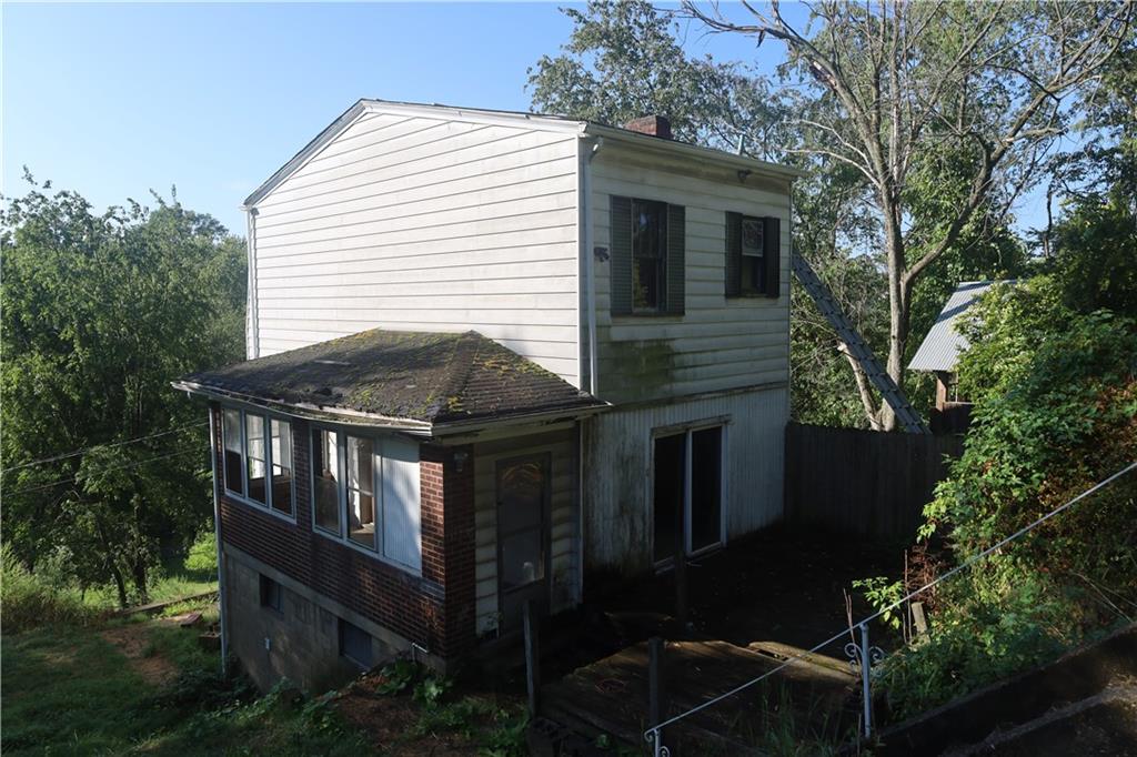 a front view of house with yard and trees around