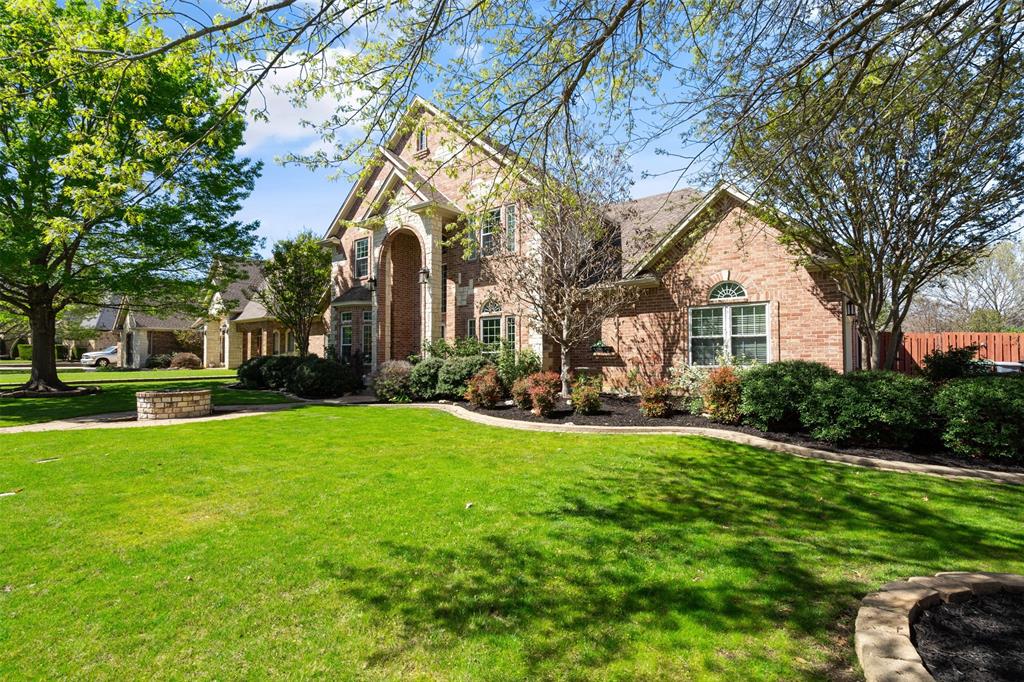 a view of a house with a big yard and large trees