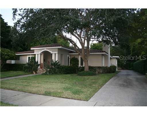 a front view of a house with a yard and trees