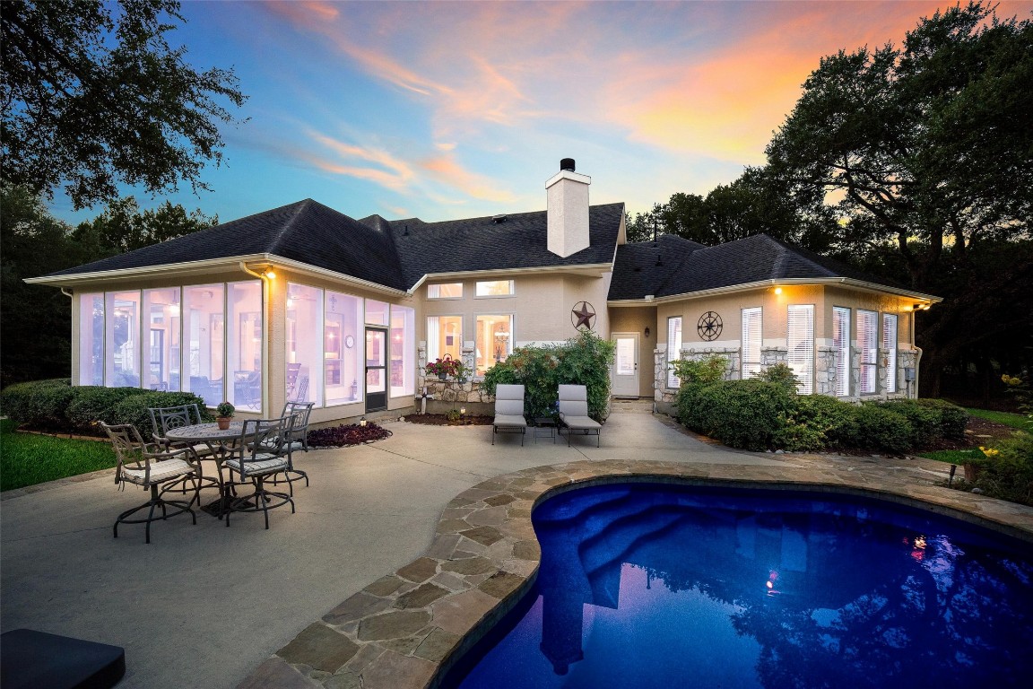 a view of a house with swimming pool and sitting area