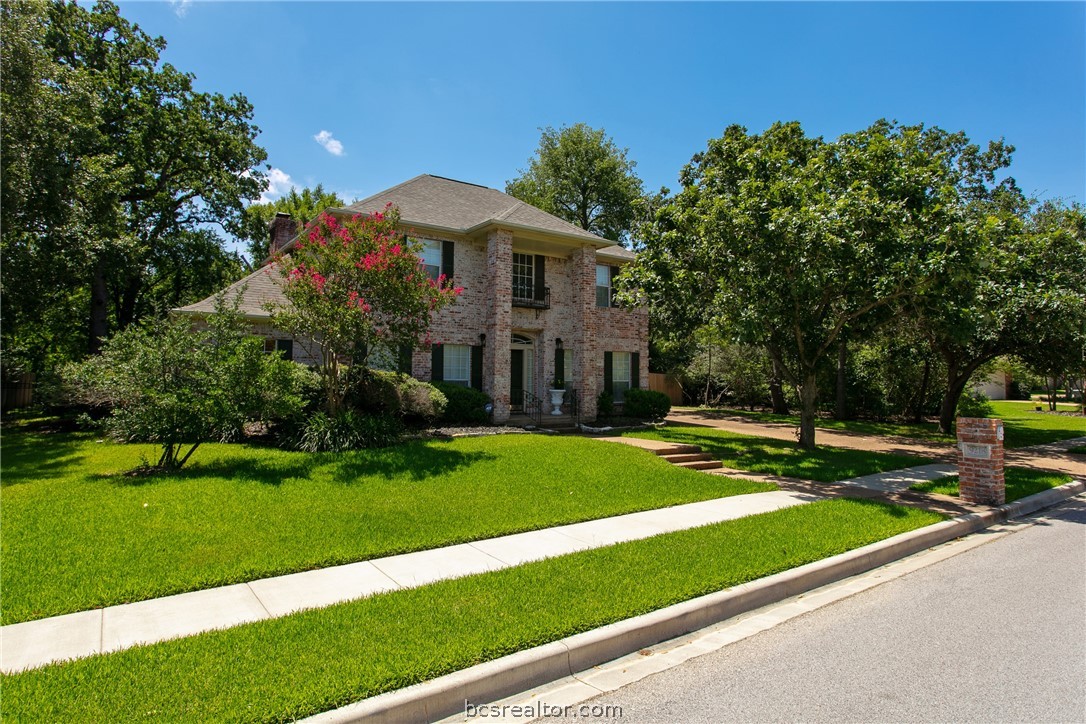 a view of a house with a yard and tree s