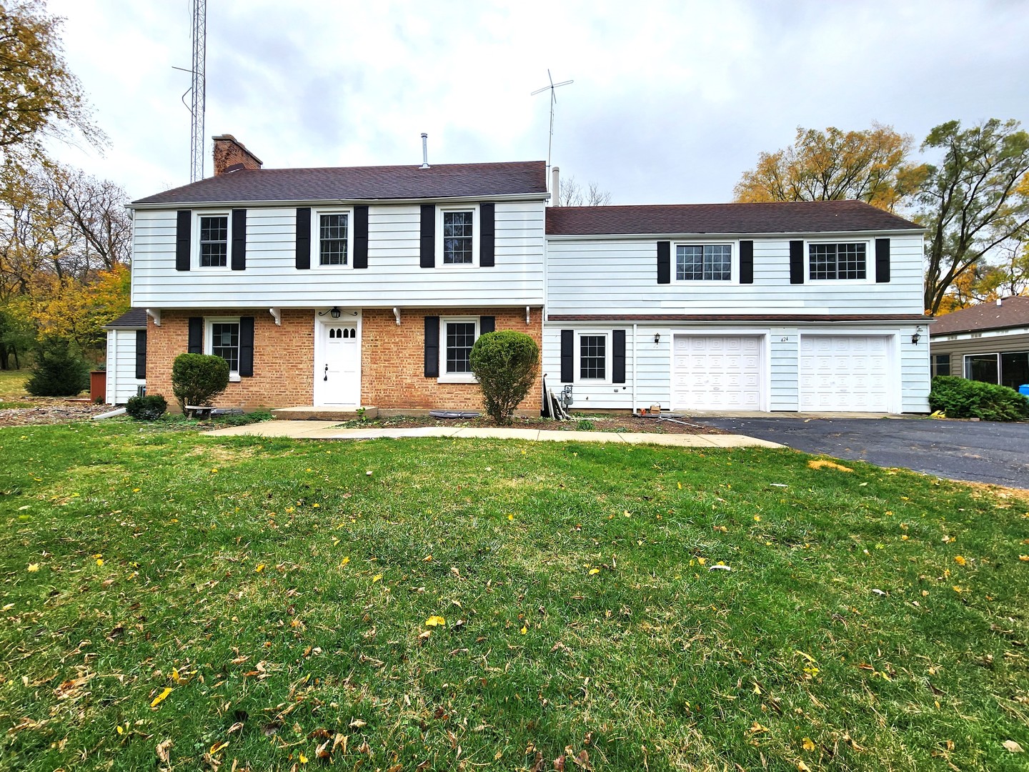 a front view of a house with garden and houses