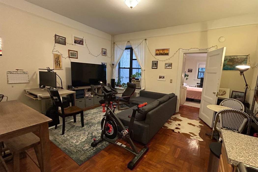 a living room with furniture a flat screen tv and gym equipment