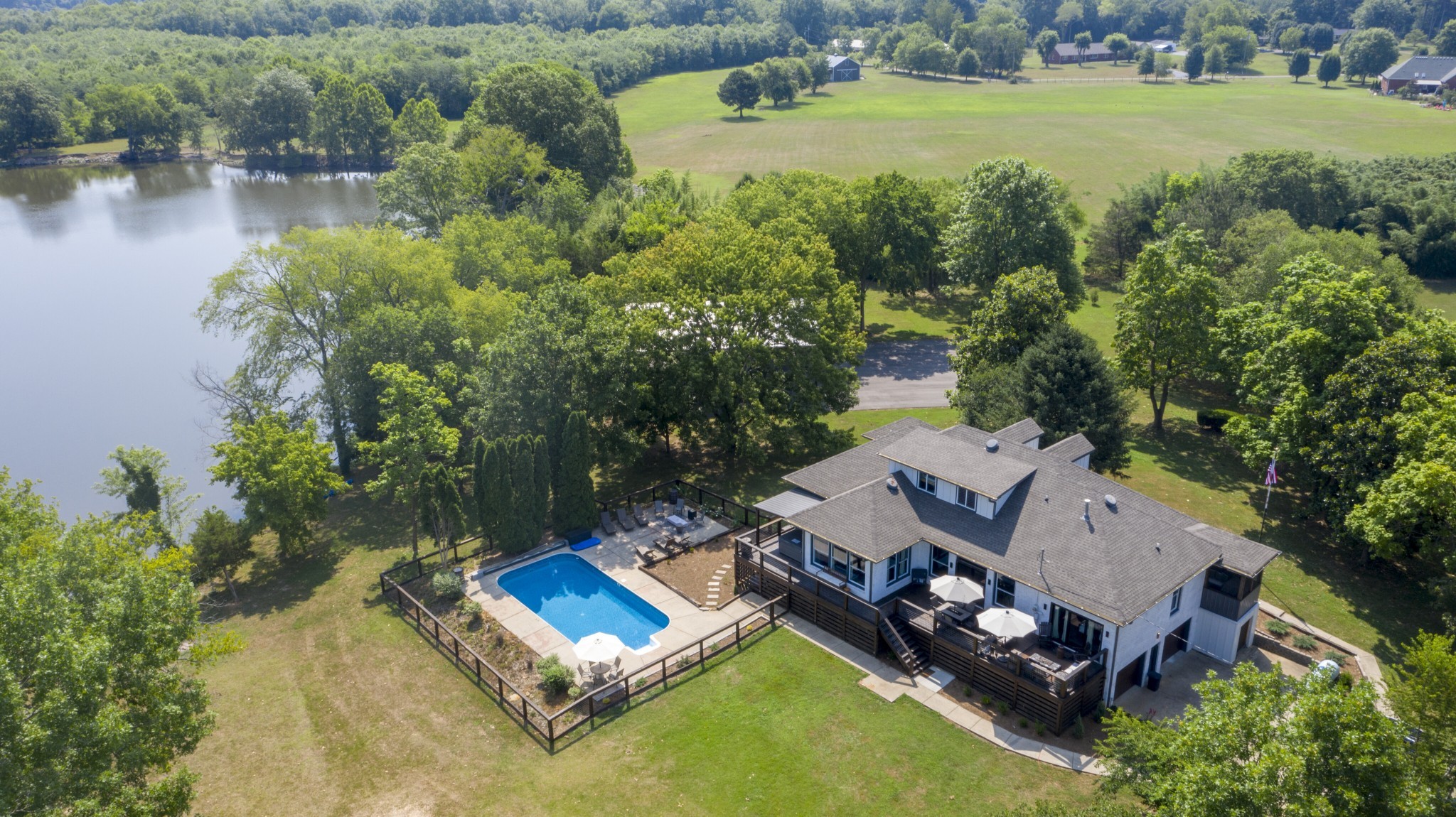 an aerial view of a house with a garden and lake view