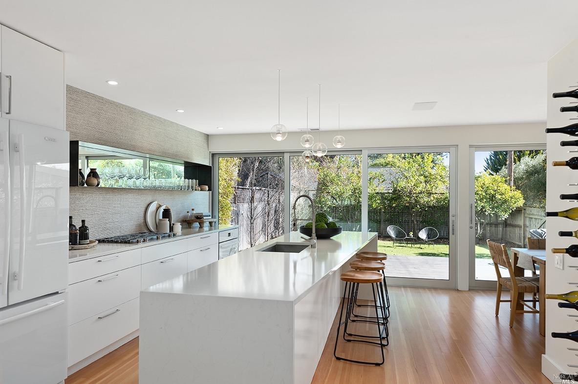 a kitchen with large windows and cabinets