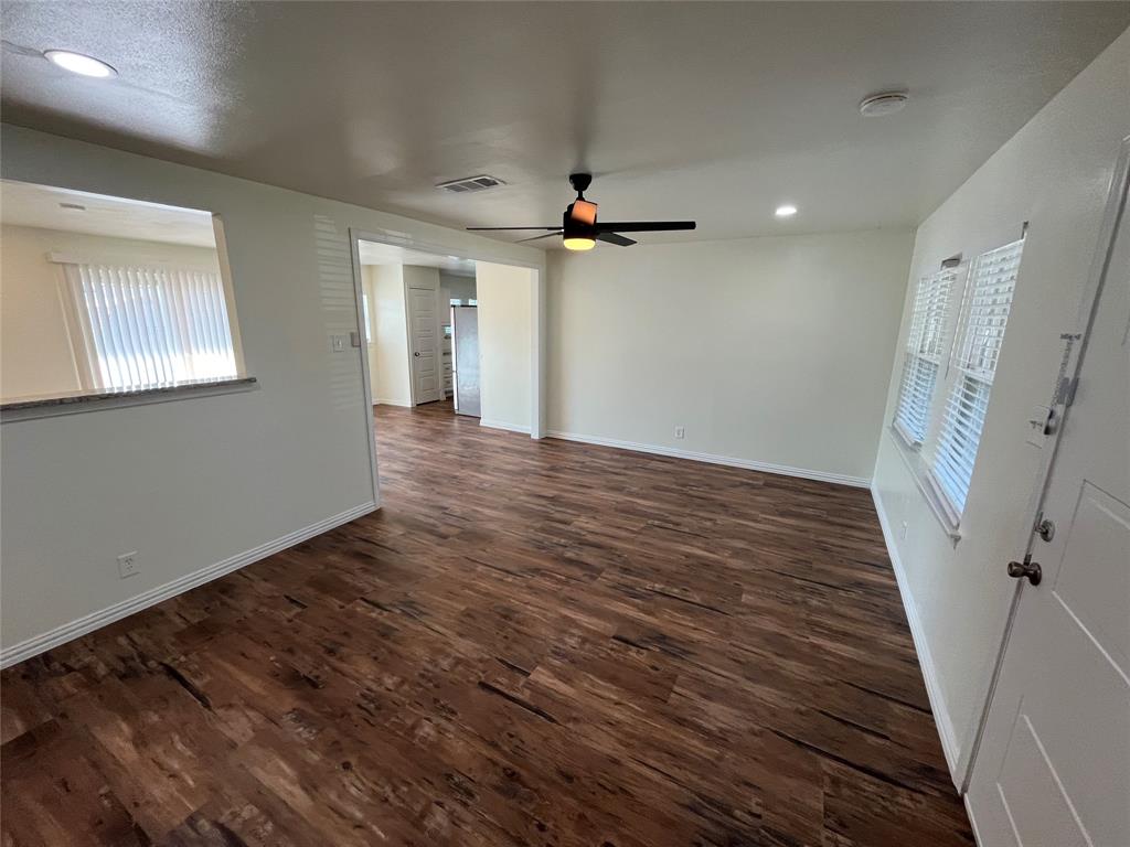 a view of a livingroom with wooden floor and a ceiling fan