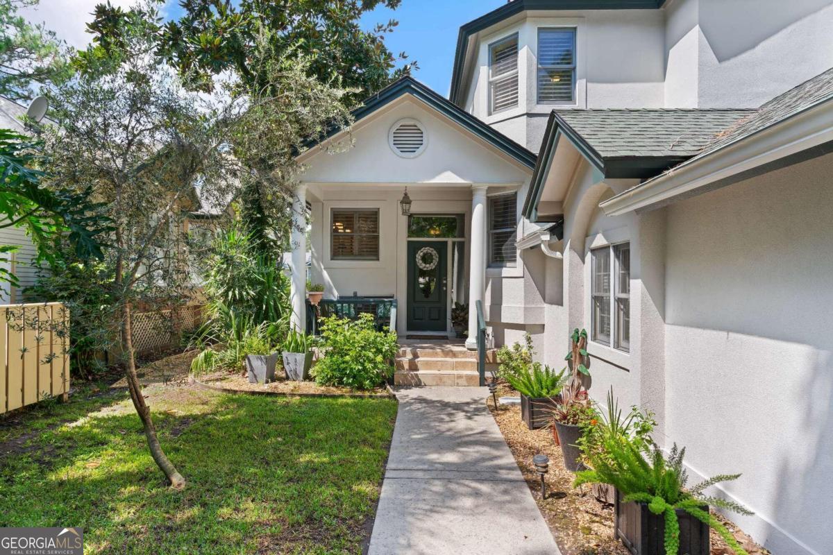 a front view of a house with a garden