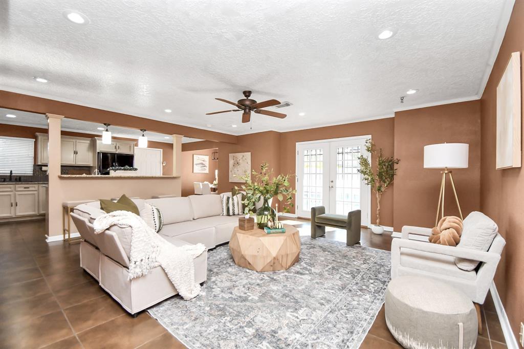 a living room with furniture a chandelier and a dining room