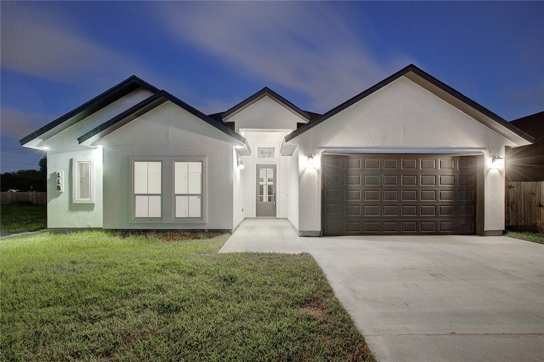 a front view of a house with yard and garage