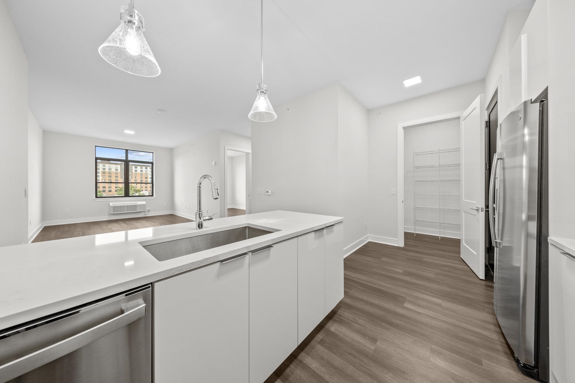 a kitchen with a sink and wooden floor