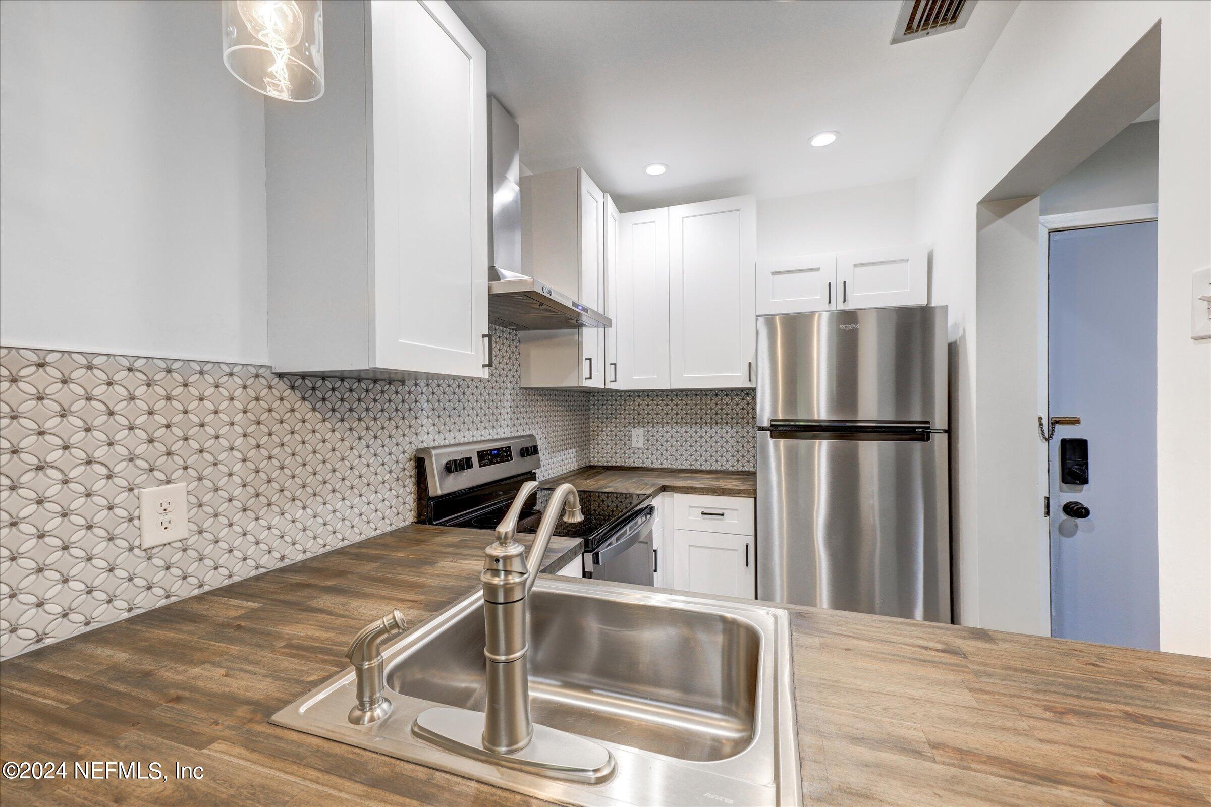 a kitchen with a refrigerator sink and cabinets