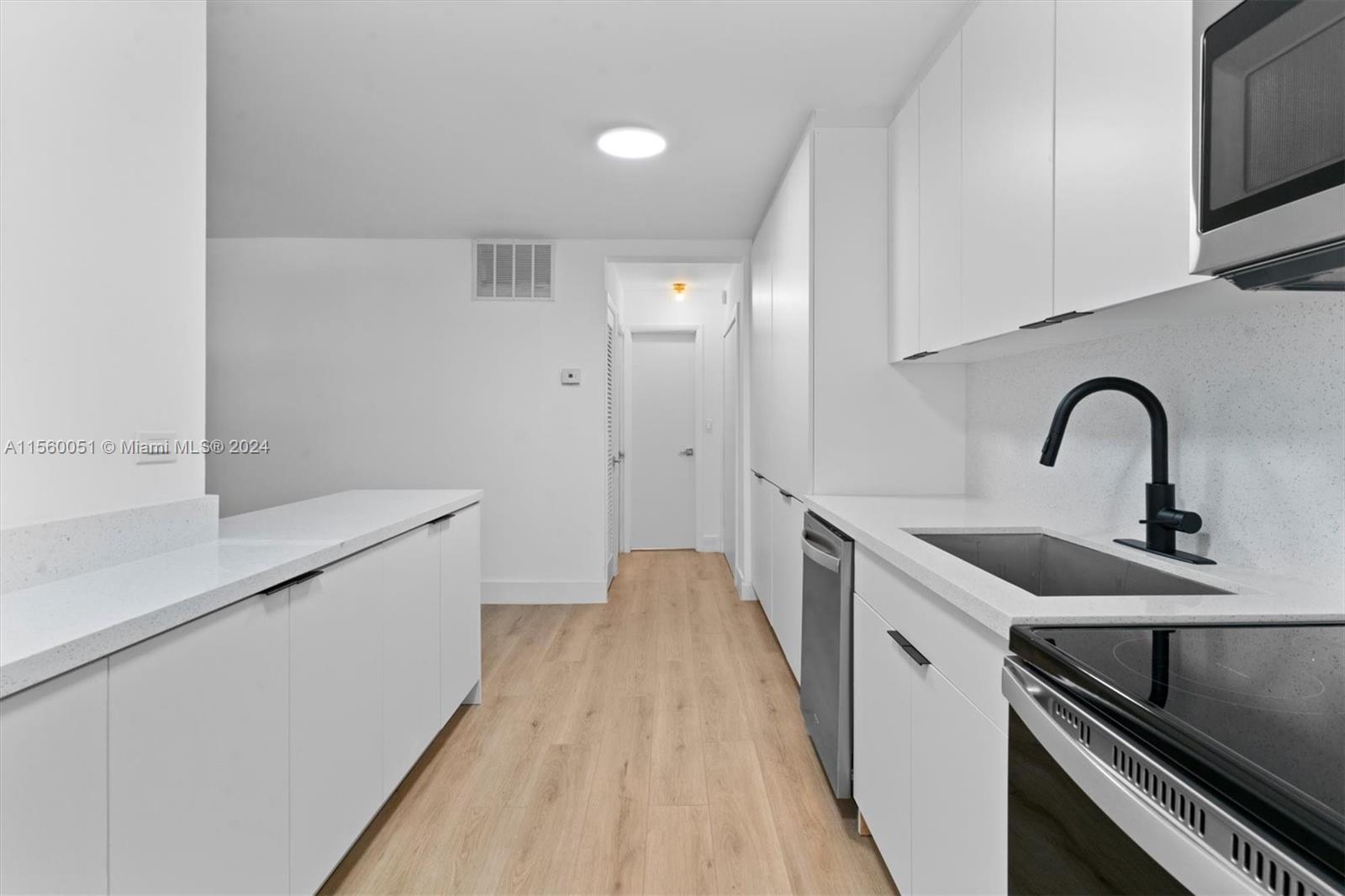 a kitchen with a sink and wooden floor