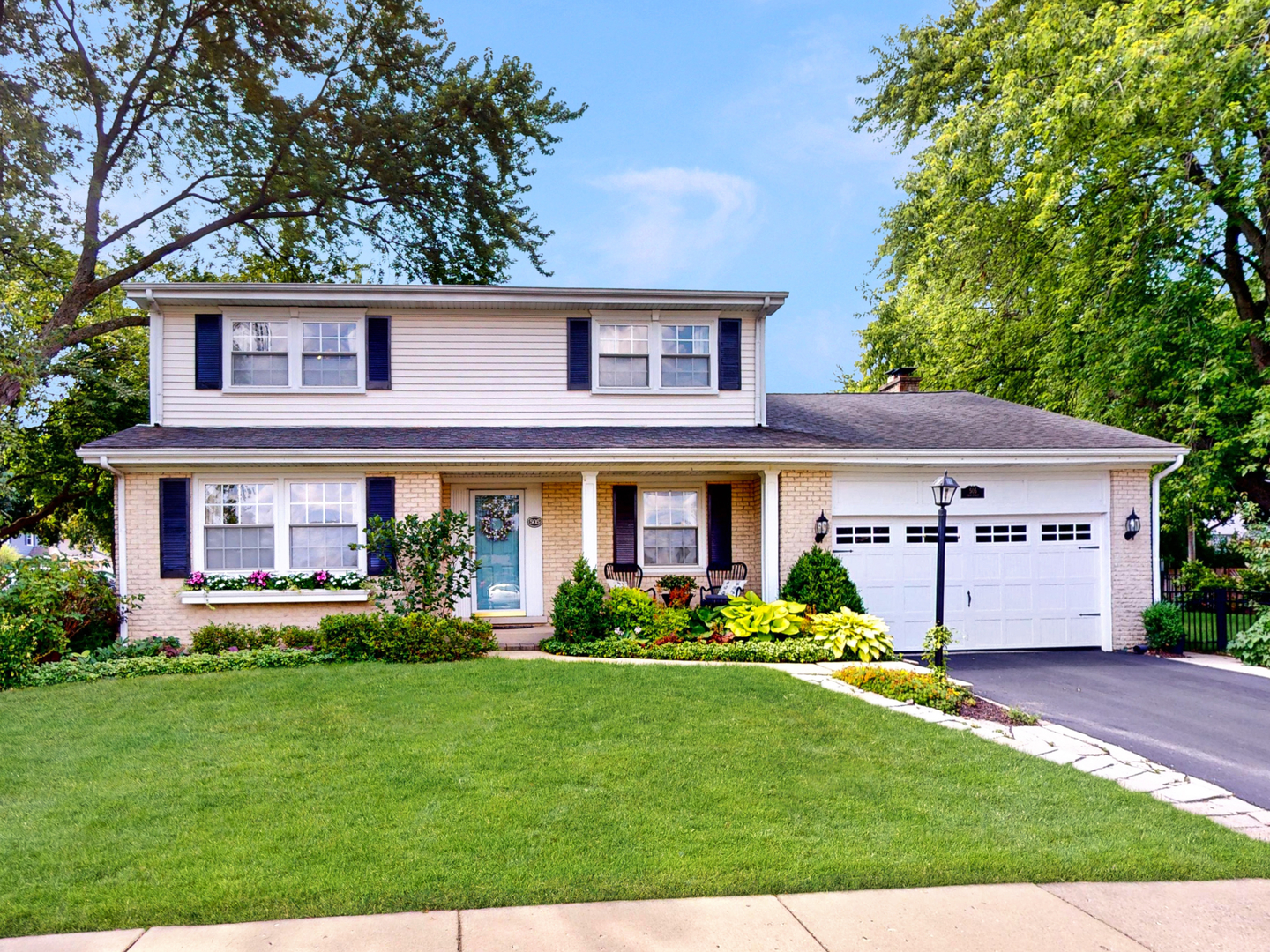 a front view of a house with a garden and plants