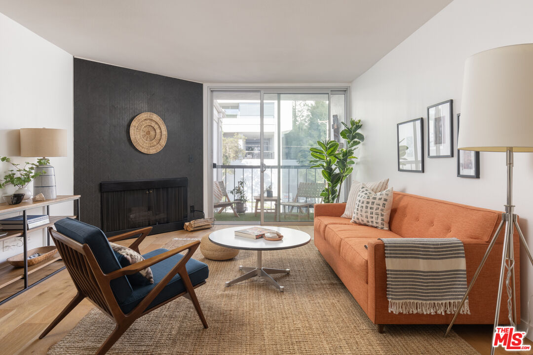 a living room with furniture a fireplace and a large window